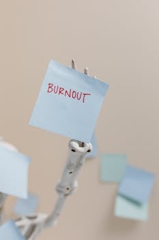 A skeleton holding a sticky note reading 'Burnout', symbolizing workplace stress.