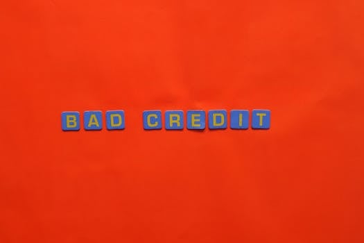 Blue letter blocks spelling 'Bad Credit' on an orange background.