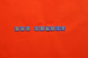 Blue letter blocks spelling 'Bad Credit' on an orange background.